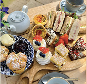 A Selection of sandwiches, quiche and scones with a pot of tea