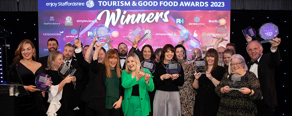 Winners of the 2023 Enjoy Staffordshire Tourism & Good Food Awards competition celebrate on stage with their trophies