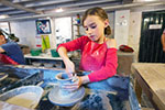 Girl making a clay pot on the Potter's Wheel at Gladstone Pottery Museum
