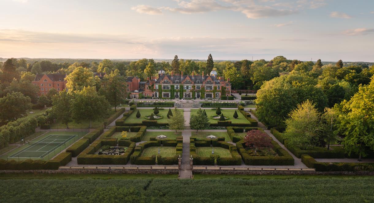 A drone shot of Hoar Cross Hall at sunrise, showing the perfectly manicured grounds and the beautiful surroundings