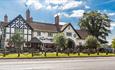 Image shows the front of The Dog & Doublet Inn, taken on a sunny day