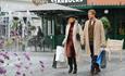 A couple with their shopping bags walk hand-in-hand