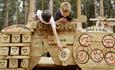 Image shows two boys 'building a bike' on the play equipment at Cannock Chase Forest's Pedal and Play Trail